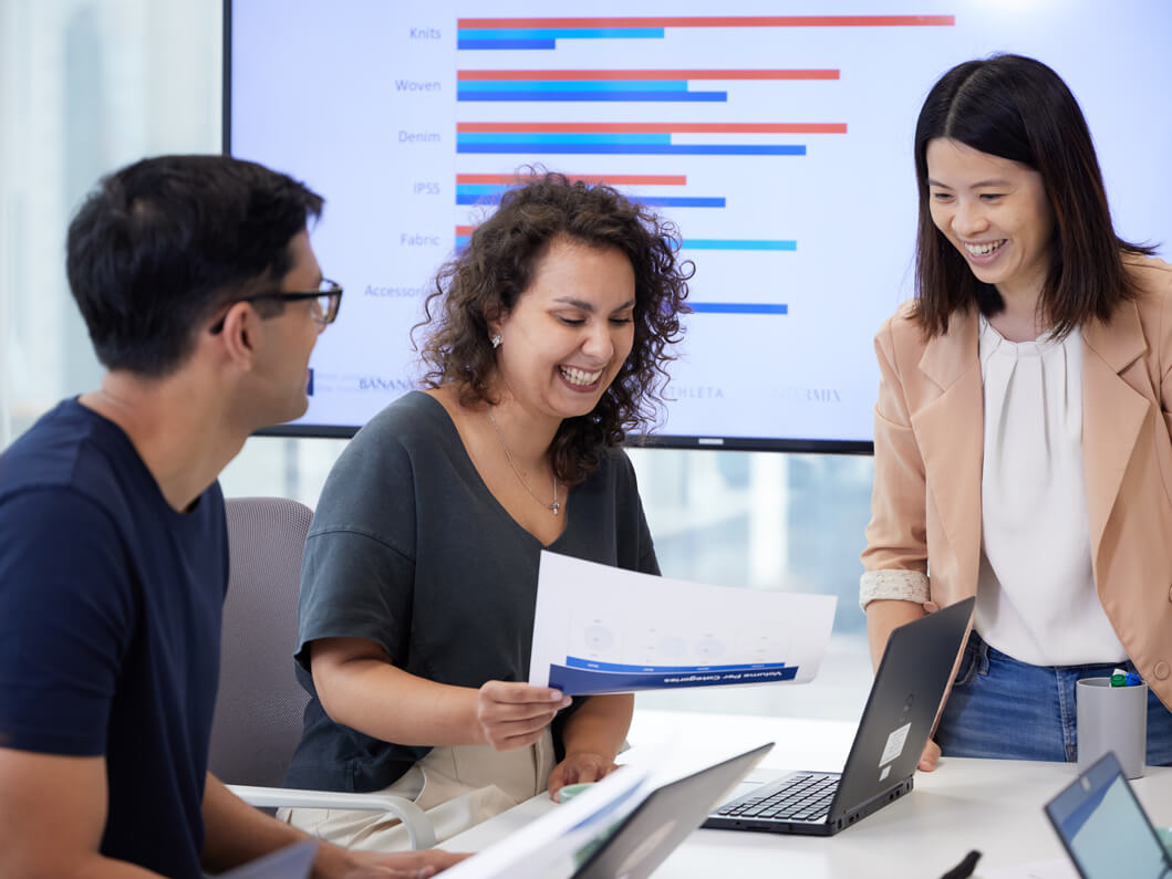 Three Employees Looking at Paperwork 